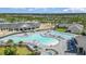 Aerial view of community pool area with lounge chairs and palm trees at 43996 Boardwalk Loop # 1411, Punta Gorda, FL 33982