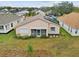 Rear view of house featuring solar panels and screened porch at 483 Winwood Ct, Port Charlotte, FL 33954