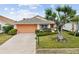 Single story house with orange garage door and large tree at 483 Winwood Ct, Port Charlotte, FL 33954