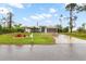 Single-story home with a large yard, driveway, and American flag at 5273 Crestline Ter, Port Charlotte, FL 33981