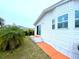 Side view of a white mobile home with a small lawn, palm trees and orange walkway at 6642 Acacia Ct, North Port, FL 34287