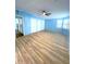 Bright bedroom featuring light blue walls, wood-look floors, and three large closets at 6642 Acacia Ct, North Port, FL 34287