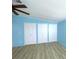 Spacious bedroom with light blue walls, wood-look flooring, and ample closet space at 6642 Acacia Ct, North Port, FL 34287