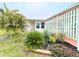 Landscaped front yard with tropical plants and a white fence at 6642 Acacia Ct, North Port, FL 34287