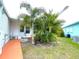 Side view of a mobile home with walkway and tropical plants at 6642 Acacia Ct, North Port, FL 34287