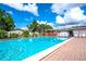 Community swimming pool with lounge chairs and covered area at 6642 Acacia Ct, North Port, FL 34287