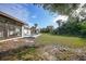 Spacious backyard with grassy area, pool, and screened patio at 813 Thornton Nw Ave, Port Charlotte, FL 33948