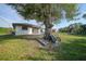 Large backyard with mature tree, wheelbarrow, and ladder at 813 Thornton Nw Ave, Port Charlotte, FL 33948