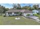 Single story home with attached garage, landscaped lawn, and circular driveway at 813 Thornton Nw Ave, Port Charlotte, FL 33948