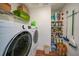 Bright laundry room with washer, dryer, and ample storage shelving at 813 Thornton Nw Ave, Port Charlotte, FL 33948