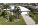 Single-Gathering home with a metal roof, lush landscaping, and a paved driveway at 1022 Lucia Dr, Punta Gorda, FL 33950