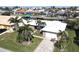 Single-story home with a white roof, palm trees, and a paved driveway, located in a waterfront community at 1022 Lucia Dr, Punta Gorda, FL 33950