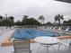 Community swimming pool with lounge chairs and table at 1246 Rio De Janeiro Ave # 503, Punta Gorda, FL 33983