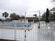 Community pool with fence, chairs, and patio umbrella at 1246 Rio De Janeiro Ave # 503, Punta Gorda, FL 33983