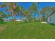 Spacious backyard with lush grass and palm trees at 1325 Goshen Rd, North Port, FL 34288