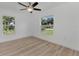 Bright bedroom with wood-look floors, ceiling fan, and large windows at 1325 Goshen Rd, North Port, FL 34288