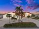 Single-story home with red tile roof and lush tropical landscaping at 136 Creek Se Dr, Port Charlotte, FL 33952