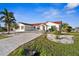 White single-story home with red tile roof, landscaping, and a long driveway at 136 Creek Se Dr, Port Charlotte, FL 33952