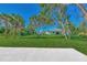 Landscaped backyard with grassy area and palm trees at 1543 Gorham St, North Port, FL 34288