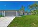 New construction home with gray garage door and lush lawn at 1543 Gorham St, North Port, FL 34288