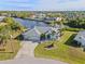 Aerial view of waterfront home with canal access, lush landscaping, and a two-car garage at 17456 Foremost Ln, Port Charlotte, FL 33948