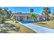 Tan house with red door, palm trees, and landscaped yard at 19071 Helena Ave, Port Charlotte, FL 33948