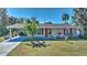 Tan house with red door, palm trees, and landscaped yard at 19071 Helena Ave, Port Charlotte, FL 33948