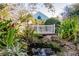 White footbridge over a tranquil stream in a lush garden at 19375 Water Oak Dr # 203, Port Charlotte, FL 33948