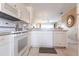 White kitchen with stainless steel appliances and view into living area at 19375 Water Oak Dr # 203, Port Charlotte, FL 33948