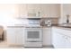 Bright eat-in kitchen features white cabinetry, microwave, oven, and dishwasher at 19375 Water Oak Dr # 203, Port Charlotte, FL 33948
