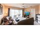 Living room with brown leather couch, balcony access, and view of the water at 19375 Water Oak Dr # 203, Port Charlotte, FL 33948