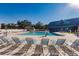 Community pool with lounge chairs and adjacent clubhouse at 19375 Water Oak Dr # 203, Port Charlotte, FL 33948