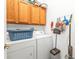 Laundry room with washer, dryer, and overhead cabinets at 24304 Westgate Blvd, Port Charlotte, FL 33980