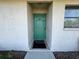 Light teal front door with a small welcome mat at 24540 Harborview Rd # F1, Punta Gorda, FL 33980