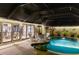 Night view of a relaxing pool area with covered patio and lighting at 25188 Marion Ave # 12, Punta Gorda, FL 33950