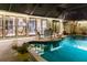 Night view of a relaxing pool and patio area with comfortable seating at 25188 Marion Ave # 12, Punta Gorda, FL 33950