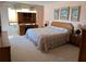 Bright bedroom featuring a bed with floral bedding, a desk with hutch, and three decorative beach-themed pictures at 25188 Marion Ave # F201, Punta Gorda, FL 33950