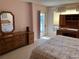 Bedroom showing a dresser with mirror, a desk with a hutch, and a doorway to a porch at 25188 Marion Ave # F201, Punta Gorda, FL 33950