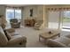 Well-lit living room with plush seating, neutral carpet and bright windows with views of tropical landscaping at 25188 Marion Ave # F201, Punta Gorda, FL 33950