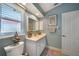 Light blue bathroom with white vanity and large mirror at 25316 Rupert Rd, Punta Gorda, FL 33983