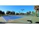 A well-maintained tennis court with a vibrant blue surface and professional lighting for evening games at 26166 Stillwater Cir, Punta Gorda, FL 33955
