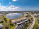 Aerial view showcasing a community near a lake, featuring multiple buildings and parking at 26397 Nadir Rd # 208, Punta Gorda, FL 33983