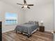 Bright bedroom with lake view, ceiling fan, and wood-look floors at 26397 Nadir Rd # 208, Punta Gorda, FL 33983