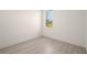 Bright bedroom with wood-look floors and a window offering natural light at 27066 Sumatra Dr, Punta Gorda, FL 33955