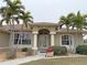 House entrance with columns, landscaping, and palm trees at 273 Mark Twain Ln, Rotonda West, FL 33947