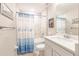 Bathroom with tub shower combo, white vanity, and blue accents at 3495 Levee St, North Port, FL 34288