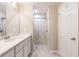 Bathroom with walk-in shower, double vanity, and white cabinets at 3495 Levee St, North Port, FL 34288