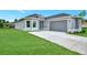 Newly built home with gray siding, attached garage, and grassy yard at 4629 Enid Ln, North Port, FL 34288
