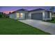 One-story home with gray exterior, two-car garage, and a well-manicured lawn at 4629 Enid Ln, North Port, FL 34288