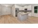 Open kitchen features an island, stainless steel appliances, and white cabinets at 4629 Enid Ln, North Port, FL 34288